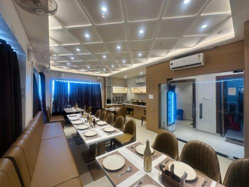 a dining room with long tables and chairs and a kitchen at hotel deep palace in Varanasi
