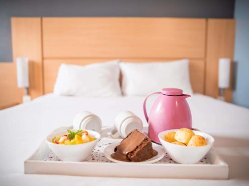 a tray with two bowls of food and a pink tea pot at ibis Itu Plaza Shopping in Itu
