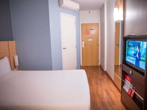 a bedroom with a bed and a flat screen tv at ibis Itu Plaza Shopping in Itu