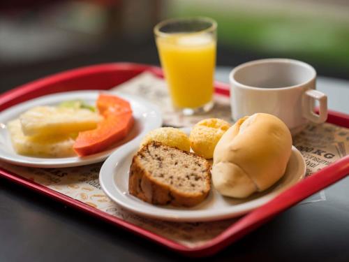 a tray with two plates of food and a cup of orange juice at ibis Itu Plaza Shopping in Itu