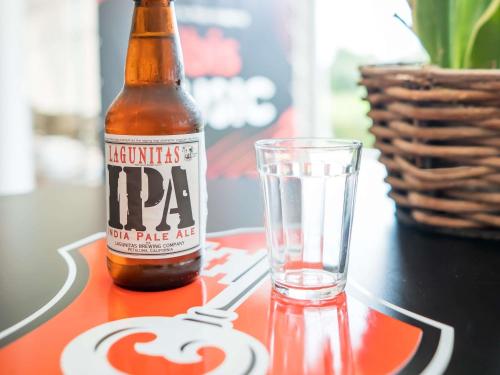 a bottle of beer and a glass on a table at ibis Itu Plaza Shopping in Itu