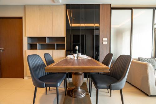 une salle à manger avec une table et des chaises en bois dans l'établissement Two Bedrooms Seaview Apartment Surin Bangtao Area 4407, à Ban Lum Fuang