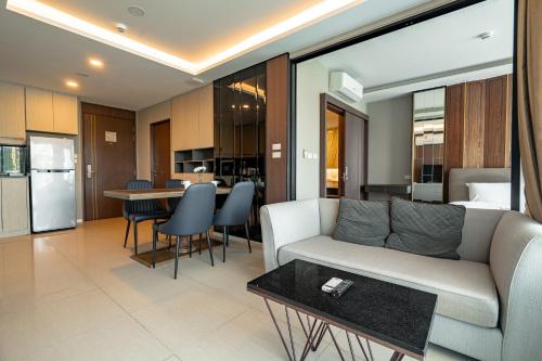 un salon avec un canapé et une table dans l'établissement Two Bedrooms Seaview Apartment Surin Bangtao Area 4407, à Ban Lum Fuang