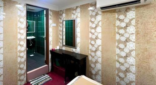 a bathroom with a fireplace and a mirror at New Wave Hotel Melawati in Taman Melawati