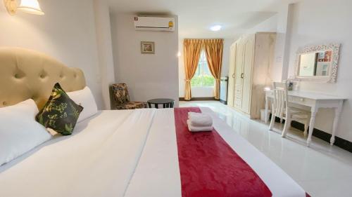 a bedroom with a large white bed with a red rug at The Target Hotel chaingrai in Chiang Rai