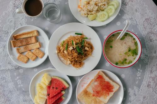 a table with plates of food and a cup of coffee at The Target Hotel chaingrai in Chiang Rai