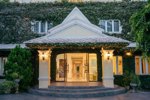 a house with a front door with ivy at The Target Hotel chaingrai in Chiang Rai