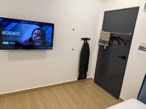 a flat screen tv hanging on a wall next to a door at Santai TTS BATU RAKIT in Kuala Terengganu