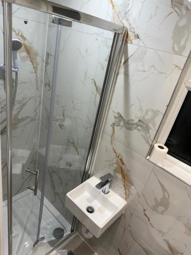 a bathroom with a sink and a shower at 58 Stylish Acton Studio Fast Central Connection in London