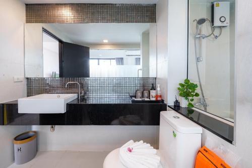 a bathroom with a sink and a toilet and a mirror at Z8 beach hotel in Jomtien Beach