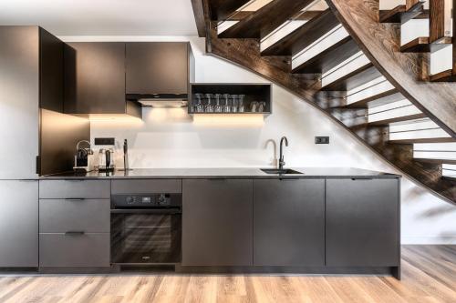 a kitchen with stainless steel appliances and a staircase at bsundrix Tiny Homes in Bludenz