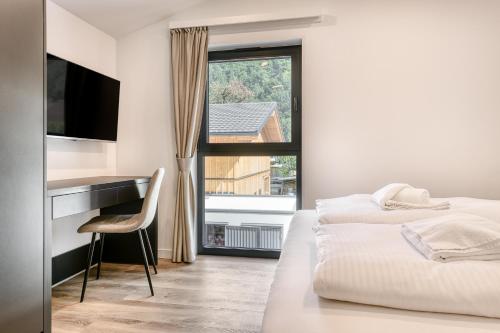 a bedroom with two beds and a desk and a window at bsundrix Tiny Homes in Bludenz