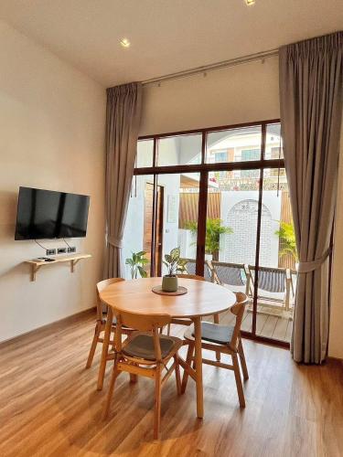 a dining room with a table and chairs and a television at Bangsaen Cabana บางแสน คาบาน่า in Ban Thai Don (1)