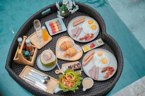 a table with breakfast foods and drinks on plates at Bangsaen Cabana บางแสน คาบาน่า in Ban Thai Don (1)
