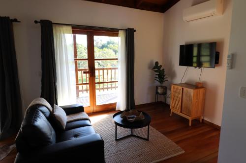 a living room with a couch and a large window at Bellingdale Farm in Clothiers Creek