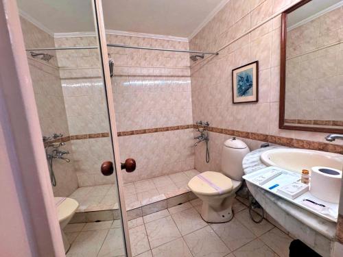 a bathroom with a shower and a toilet and a sink at asar CP Outer Circle by Orion Hotels in New Delhi