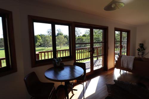 a room with a table and chairs and windows at Bellingdale Farm in Clothiers Creek