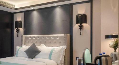 a bedroom with a white bed with a black headboard at Xana Hotelle Zhuhai Gongbei Port in Zhuhai
