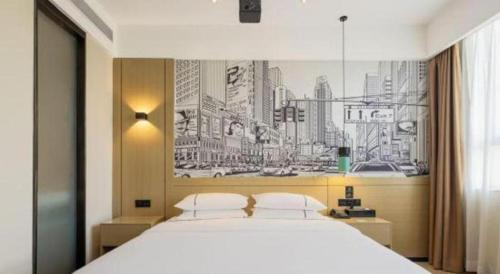 a bedroom with a large bed with a drawing on the wall at City Comfort Inn Ji'an South Administrative Center in Ji'an