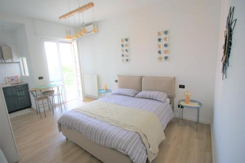 Un dormitorio blanco con una cama y una cocina. en Nest MI, en Milán