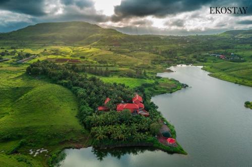 an aerial view of a house on an island in a river at EKOSTAY - Escobar Villa 8 BHK in Pune