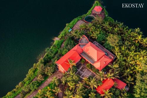 an island with a red house on top of it at EKOSTAY - Escobar Villa 8 BHK in Pune