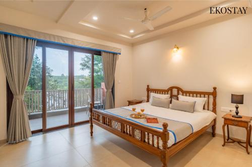 a bedroom with a bed and a balcony at EKOSTAY - Escobar Villa 8 BHK in Pune