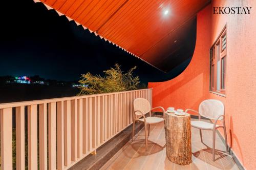 a patio with chairs and a table on a balcony at EKOSTAY - Escobar Villa 8 BHK in Pune