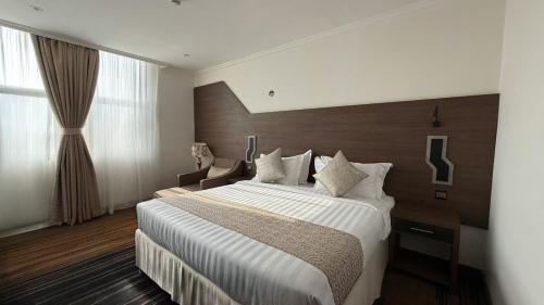 a hotel room with a large bed with white sheets at Lamar Ajyad First Hotel Tower A in Makkah