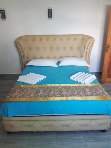 a bed in a room with a blue comforter at Hotel Sojan in Veyangoda