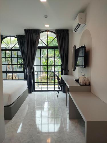 a bedroom with a bed and a desk with a television at The Target Hotel chaingrai in Chiang Rai