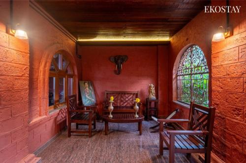 a room with a table and chairs and a window at EKOSTAY - Escobar Villa 8 BHK in Pune