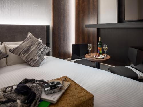 a hotel room with a bed with a camera and a table at Mitsui Garden Hotel Kyoto Kawaramachi Jokyoji in Kyoto
