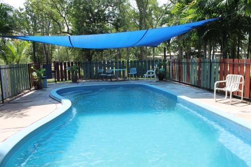 a swimming pool with a blue shade over it at Corroboree Park Tavern in Marrakai