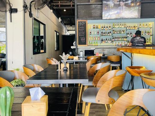 een restaurant met tafels en stoelen en een bar bij Breakers Hotel Rawai in Rawai Beach