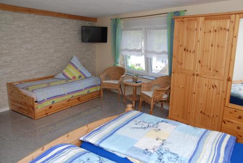 a bedroom with two beds and a couch and a table at Gästehaus Spies in Bullay