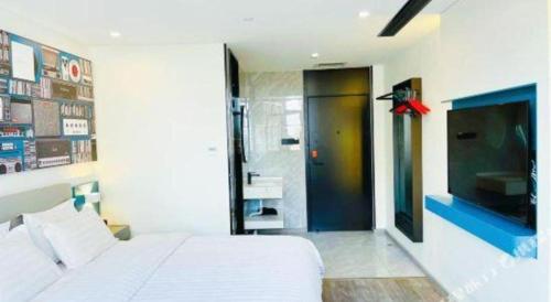 a bedroom with a white bed and a bathroom at 7 Days Inn Baoding Railway Station in Baoding