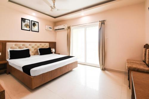 a bedroom with a bed and a large window at Super Collection O Paschim Dwar Near Jagannatha Temple in Puri