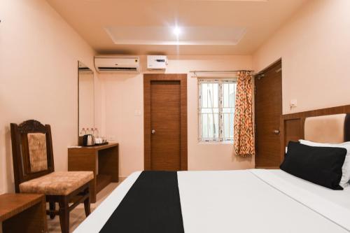 a bedroom with a bed and a chair and a window at Super Collection O Paschim Dwar Near Jagannatha Temple in Puri