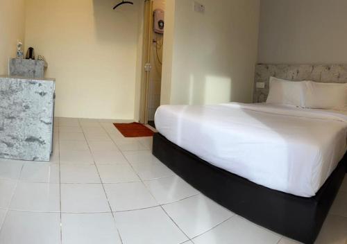 a bedroom with a large white bed in a room at D'Lima Beach Inn in Pantai Cenang
