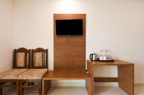 a room with two chairs and a tv on the wall at Super Collection O Paschim Dwar Near Jagannatha Temple in Puri