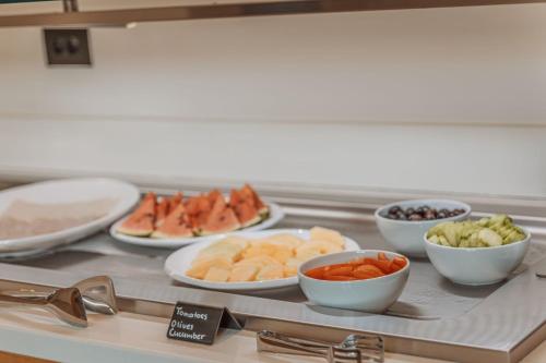 a counter with plates of food and bowls of vegetables at Aelo Mykonos Hotel in Paradise Beach