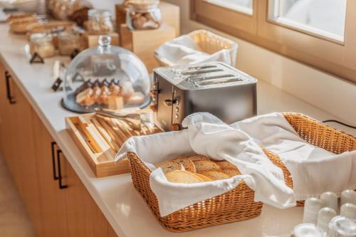a kitchen counter with baskets of bread and a toaster at Aelo Mykonos Hotel in Paradise Beach