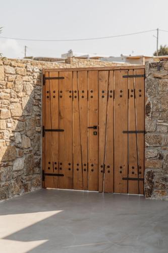 a pair of wooden doors in a stone wall at Aelo Mykonos Hotel in Paradise Beach