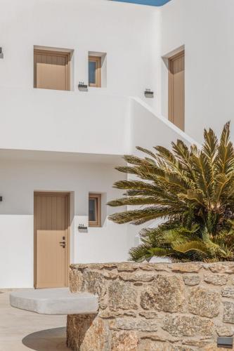 a building with a staircase and a palm tree at Aelo Mykonos Hotel in Paradise Beach