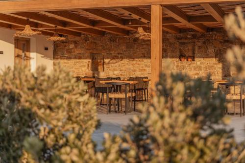 a room with tables and chairs and a brick wall at Aelo Mykonos Hotel in Paradise Beach