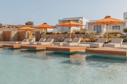 a swimming pool with lounge chairs and umbrellas at Aelo Mykonos Hotel in Paradise Beach