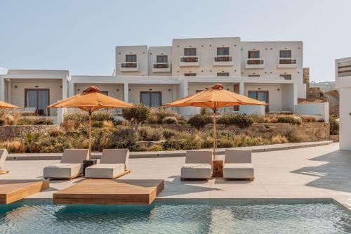 a group of chairs and umbrellas next to a pool at Aelo Mykonos Hotel in Paradise Beach