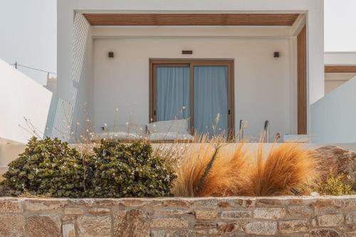 a house with a stone wall and some plants at Aelo Mykonos Hotel in Paradise Beach