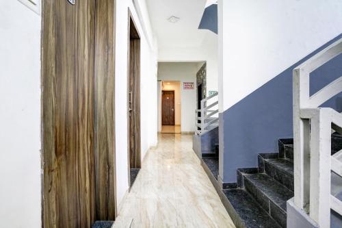 a hallway with stairs and a blue and white wall at Hotel O Nashik Road Formerly The Address Hotel in Nashik